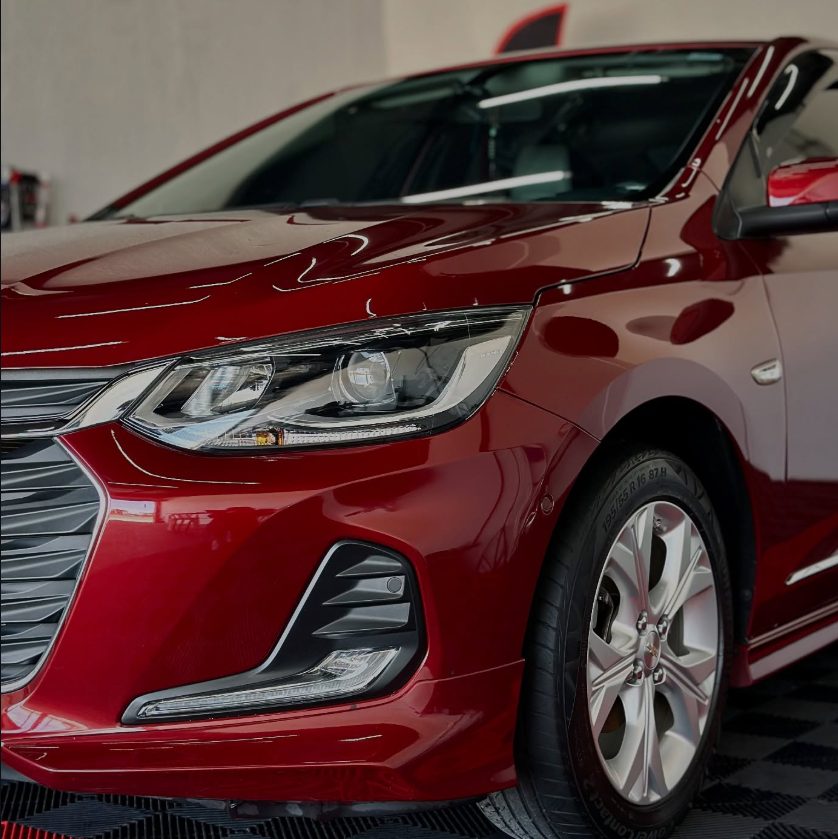 Chevrolet Onix vermelho com brilho profundo após lavagem detalhada na Bolela em Pinhais - PR